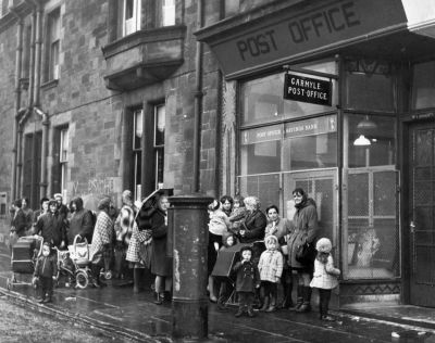 A queue of mothers and young children waiting for the Post Office to open, in Carmyle Glasgow.
